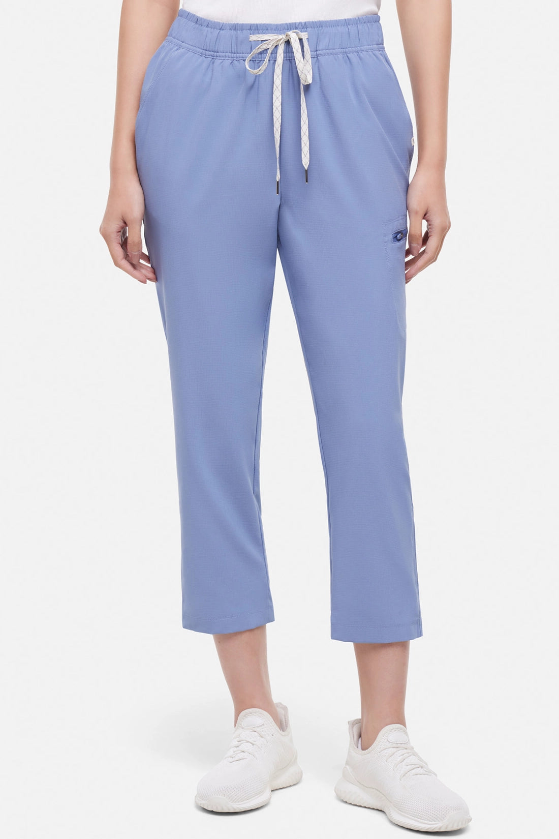 Front view of light blue pants worn by a woman with white drawstring waist on a white background.