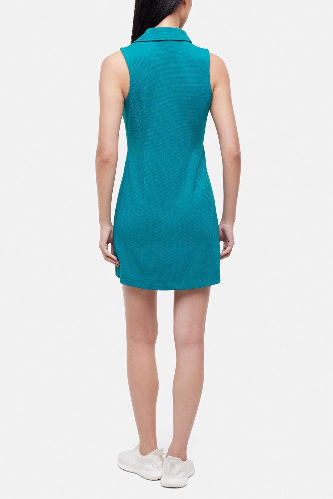 Back view of woman wearing a teal sleeveless polo dress with a white stripe collar on a white background.