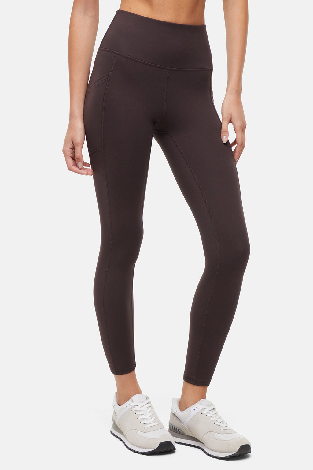 Front view of woman wearing dark brown leggings with a white background. #color_black-coffee