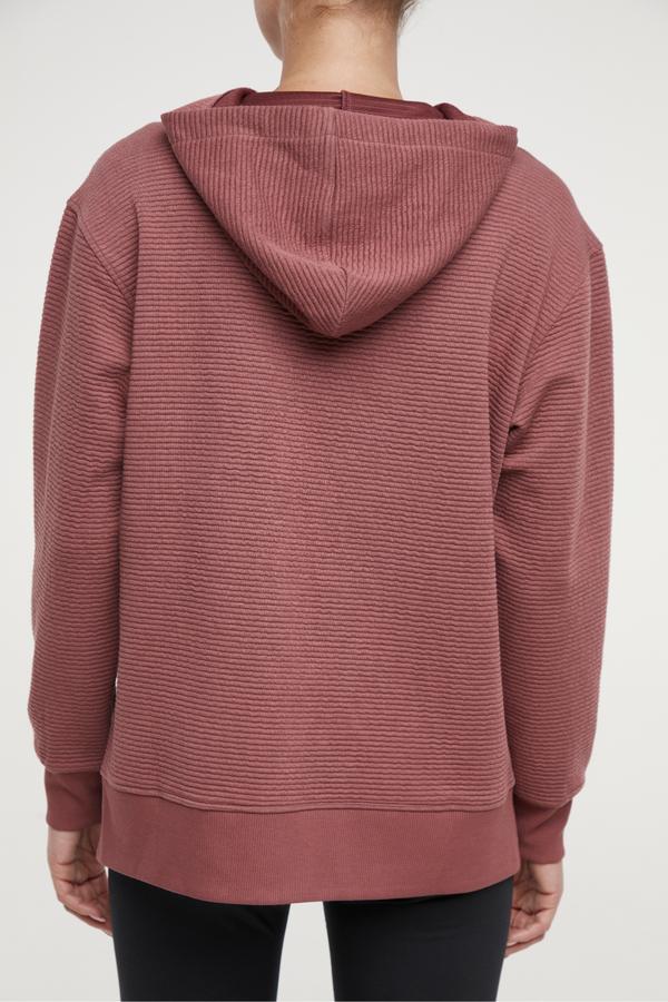 Cora Pullover Hoodie, side view showing pocket placement, showing visible design features and texture of the soft fleece fabric.. 