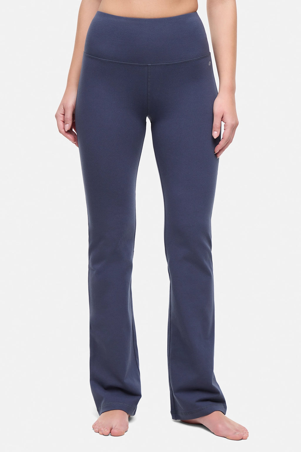 Front view of woman wearing navy blue yoga pants on a white background. #color_mood-indigo