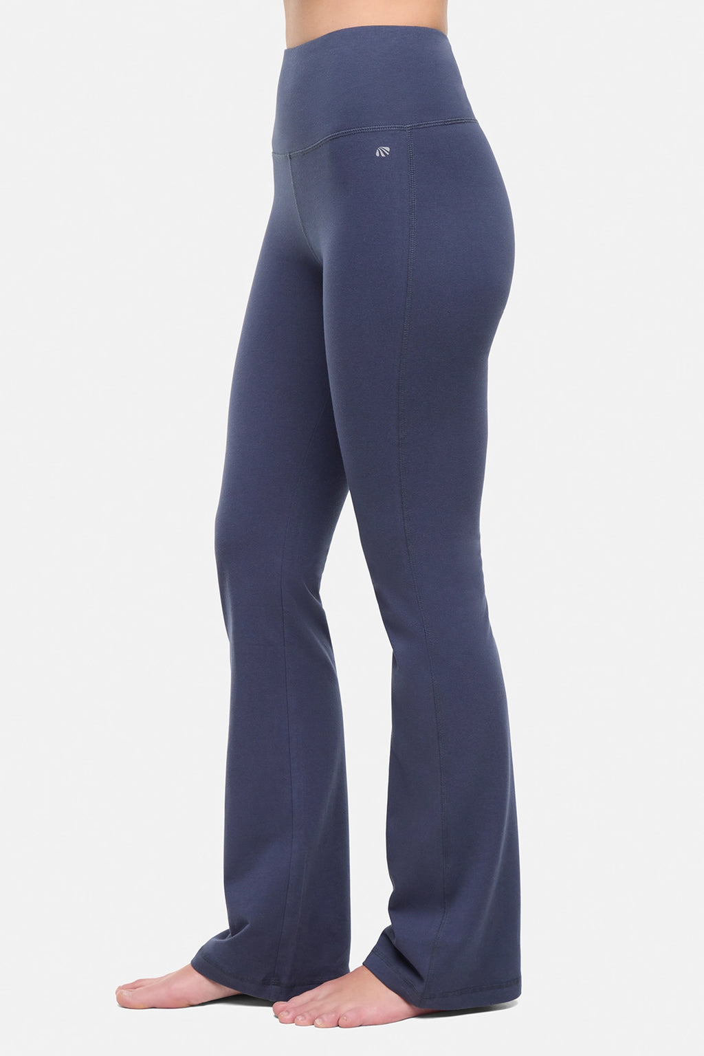 Side view of woman wearing navy blue yoga pants on a white background. #color_mood-indigo