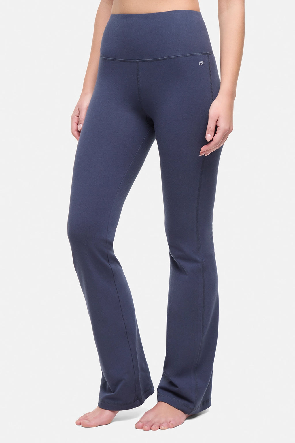 Front view of woman wearing navy blue yoga pants on a white background. #color_mood-indigo