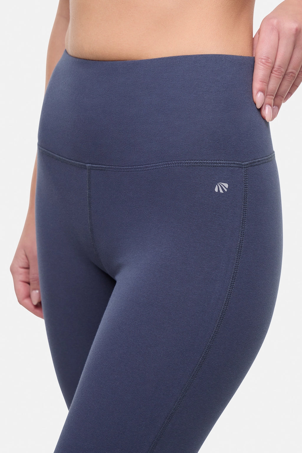 Close up front view of woman wearing navy blue yoga pants on a white background. #color_mood-indigo