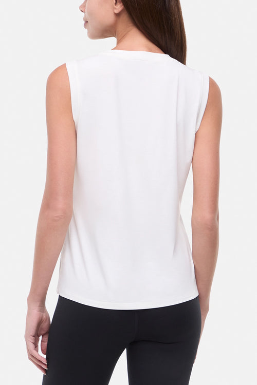 Back view of woman wearing white sleeveless shirt on a white background. #color_sugar-swizzle-abstract-hills