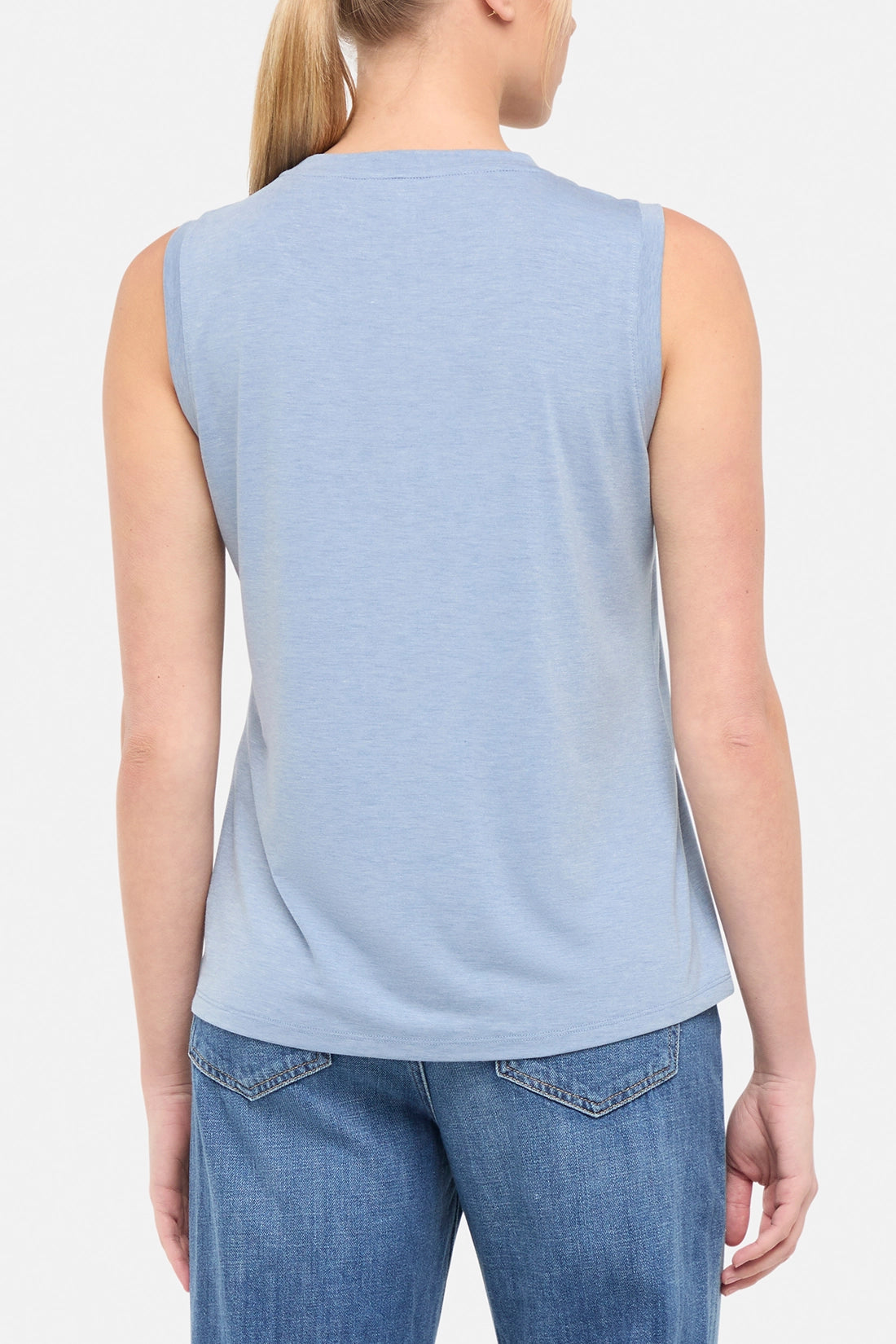 Back view of woman wearing a sleeveless light blue shirt. 