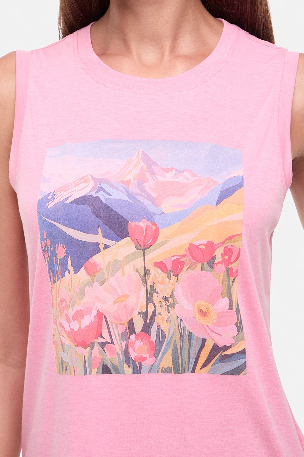 Close up view of woman wearing a pink sleeveless top with a colorful floral and mountain design on a white background. #color_heather-rosy-future-vibrant-fields