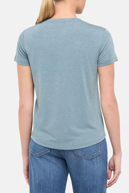 view of woman wearing a blue t-shirt  on a white background. 