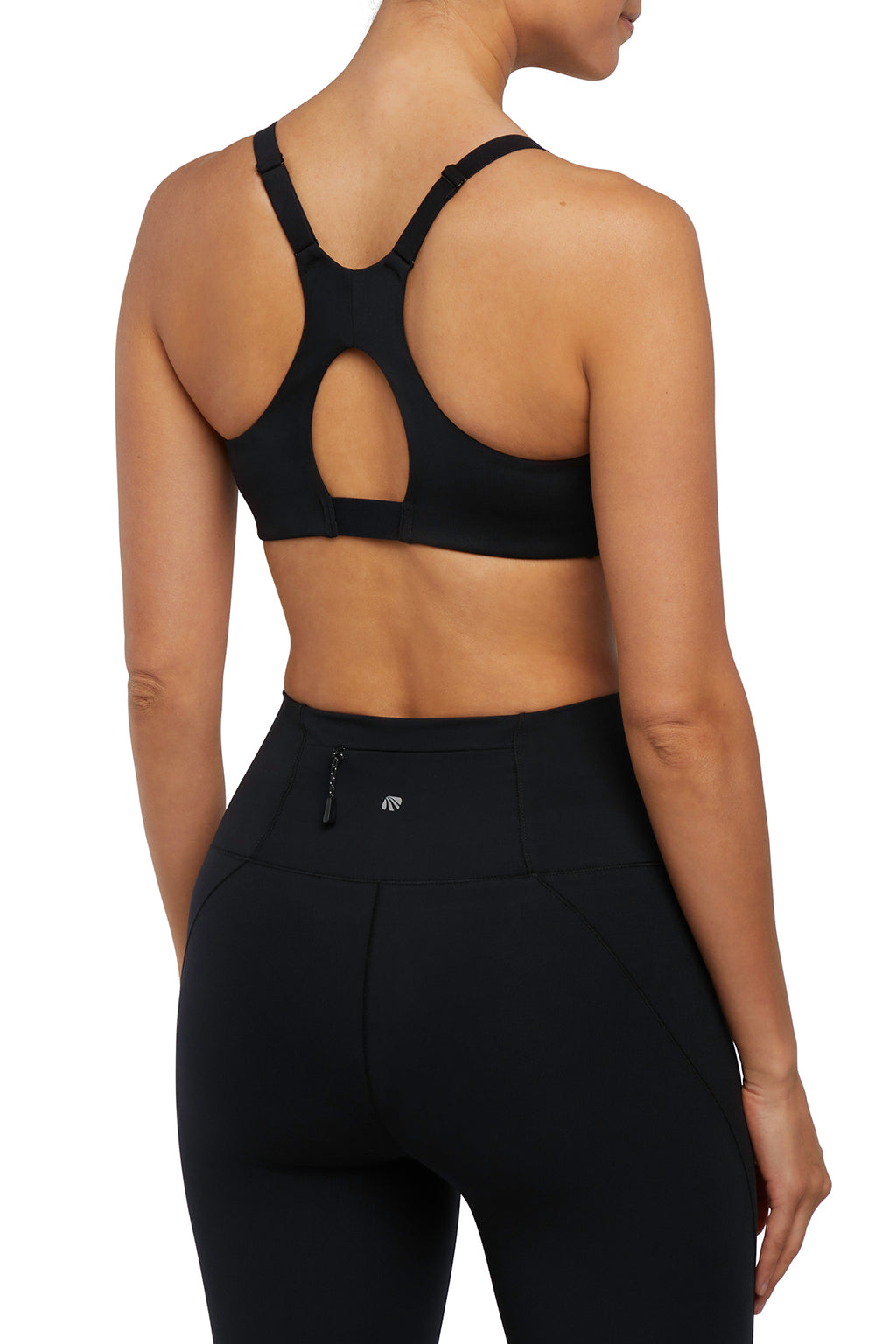 Back view of woman wearing a black sports bra and leggings on a white background. #color_black