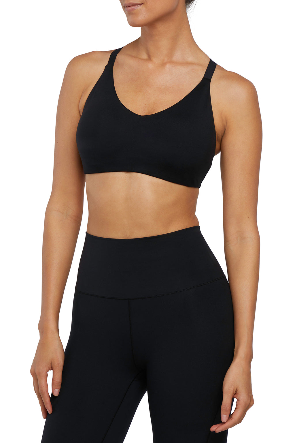 Front view of woman wearing a black sports bra and leggings on a white background. #color_black