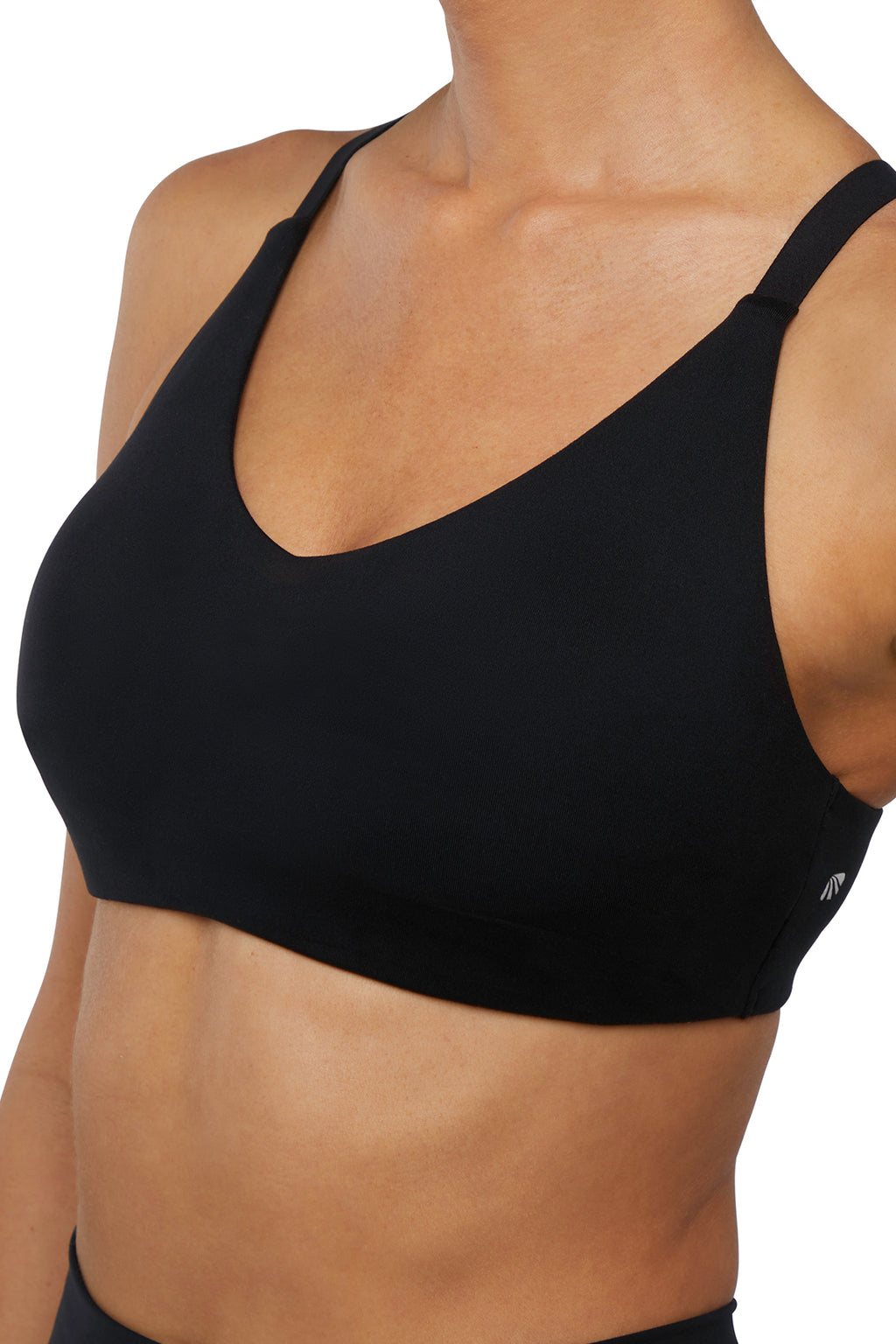 Close up front view of woman wearing a black sports bra and leggings on a white background. #color_black