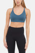 Front view of woman wearing a blue sports bra and leggings on a white background. 