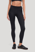A model wearing black high-waisted leggings with all around animal camo print and black sneakers, shown from the waist down against a solid light gray background. #color_black-linear-animal-camo