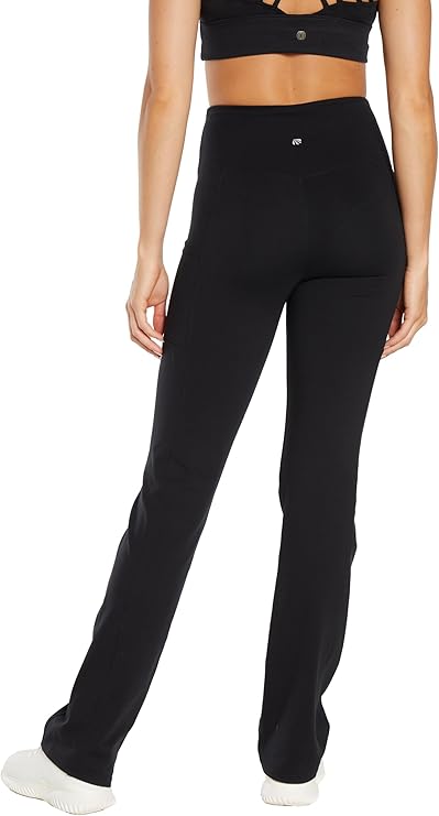 Back view of woman wearing black high-waisted pants on a white background. 