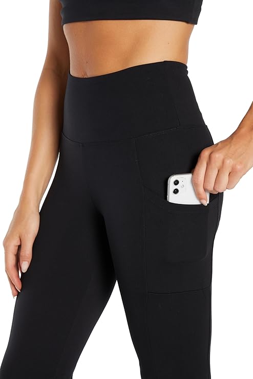 Close up front view of woman wearing black high-waisted pants on a white background. 