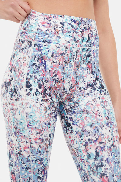 Close up front view of woman wearing colorful floral capris on a white background. 