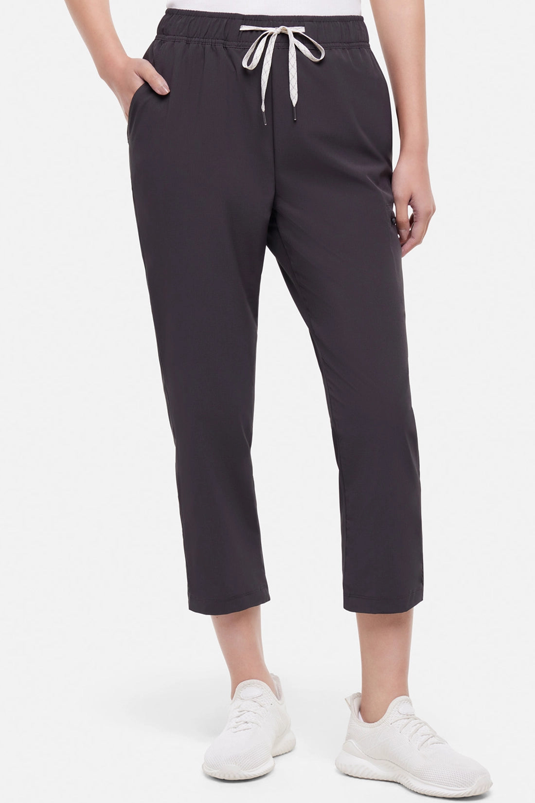 Front view of woman wearing black cropped pants with a white drawstring on a white background.