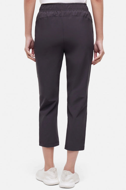 Back view of woman wearing black cropped pants with a white drawstring on a white background. #color_phantom