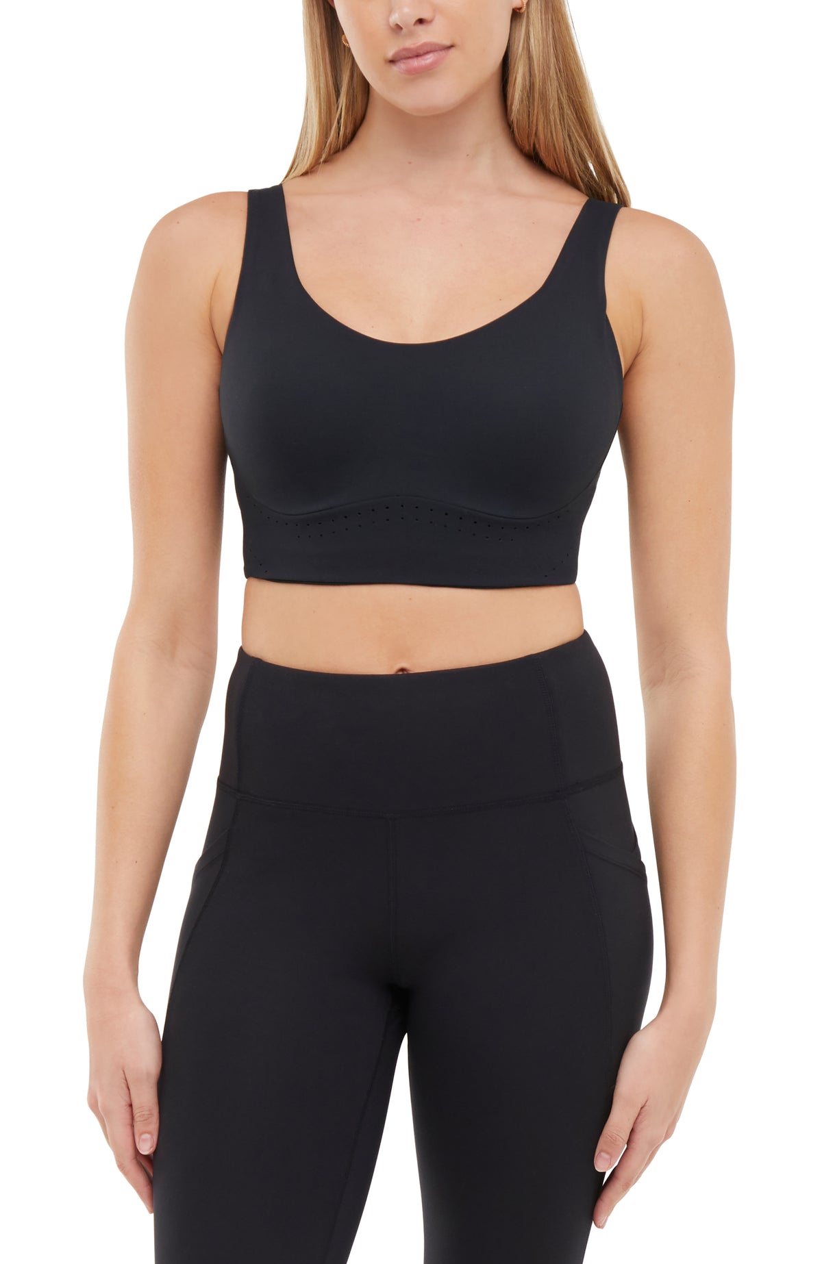 Front view of woman wearing a black sports bra and matching black leggings on a white background.