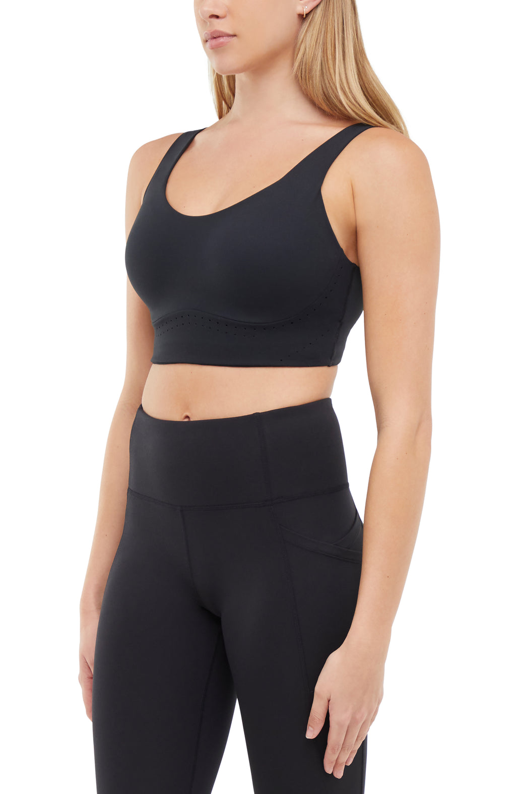Quarter view of woman wearing a black sports bra and matching black leggings on a white background. #color_black