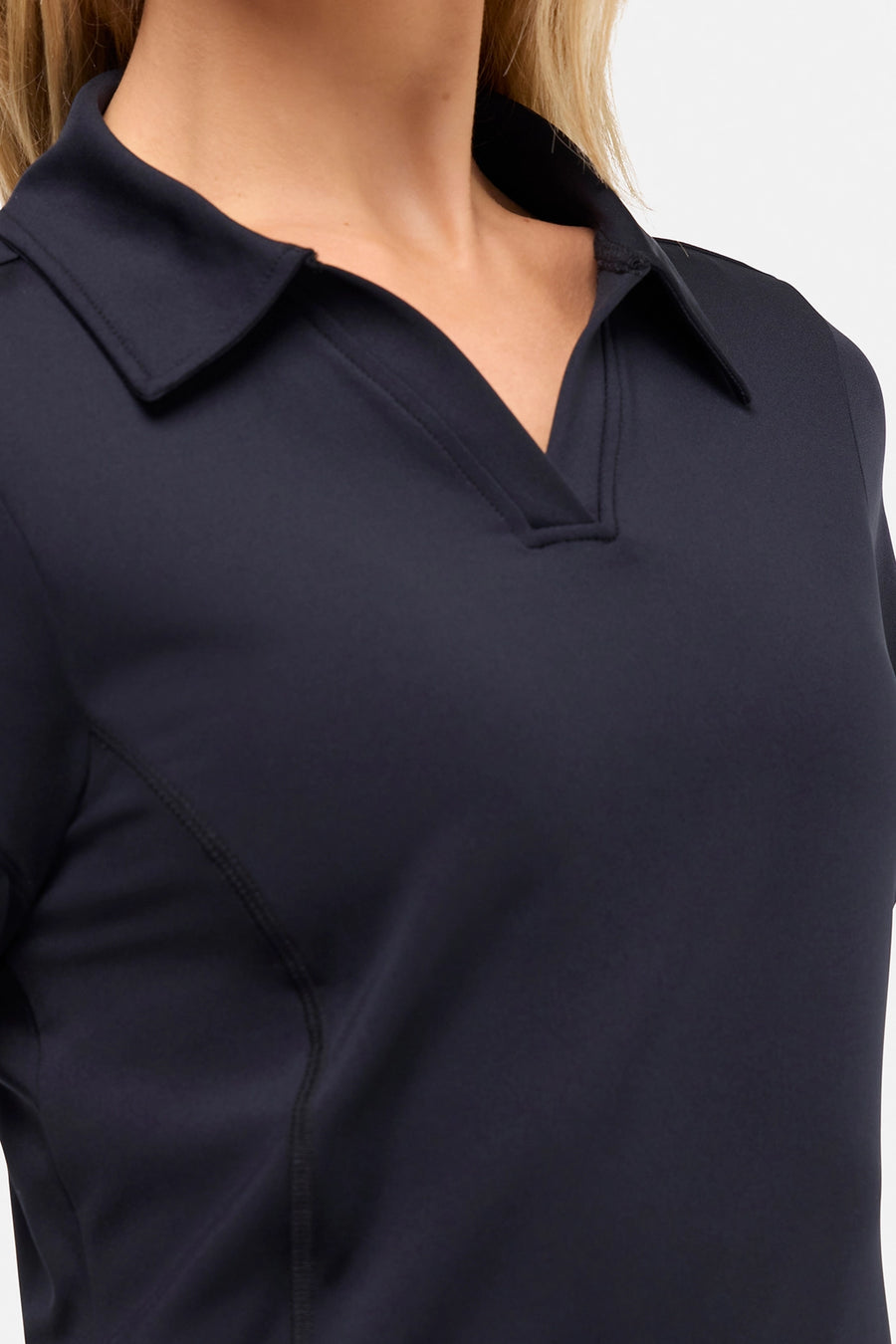 Close up front view of woman wearing a black polo shirt and black pants on a white background. #color_black