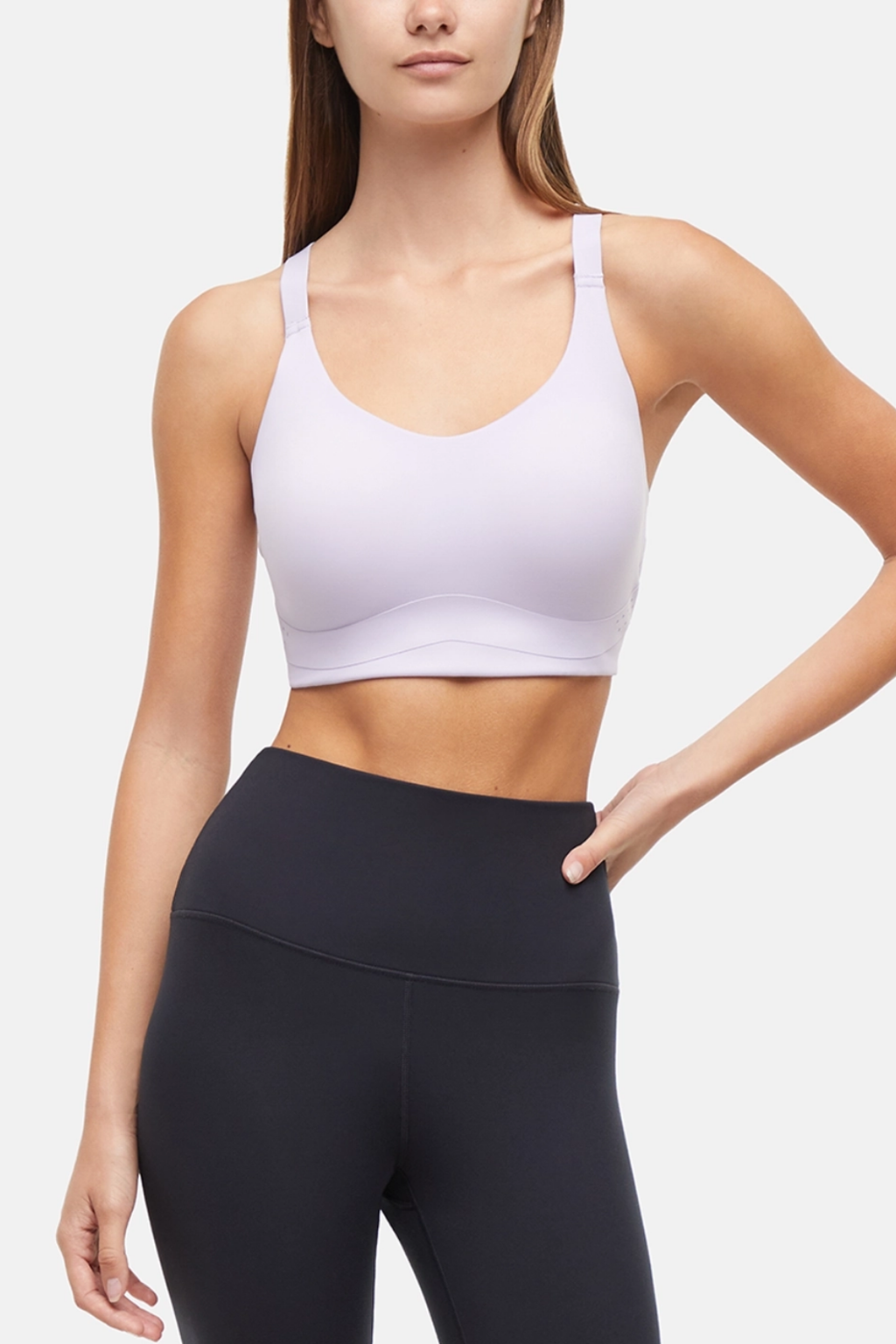 Front view of woman wearing a lilac sports bra and black leggings on a light gray background. #color_lilac-clematis