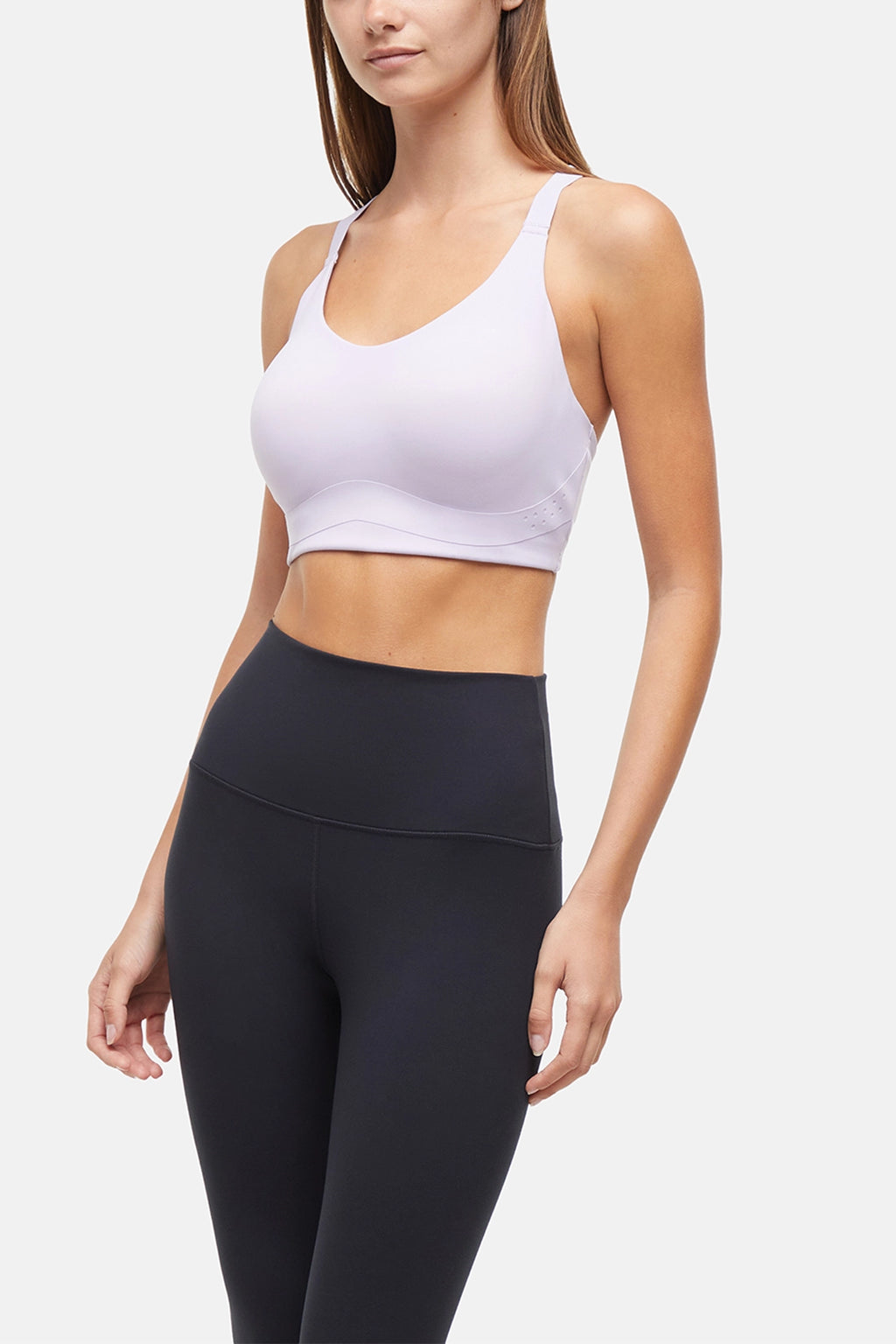 Front view of woman wearing a lilac sports bra and black leggings on a light gray background. #color_lilac-clematis