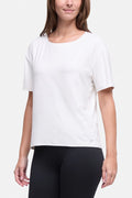 A woman wearing a white short-sleeve crewneck athletic top and black leggings, shown from the nose down against a light gray studio background. #color_sugar-swizzle