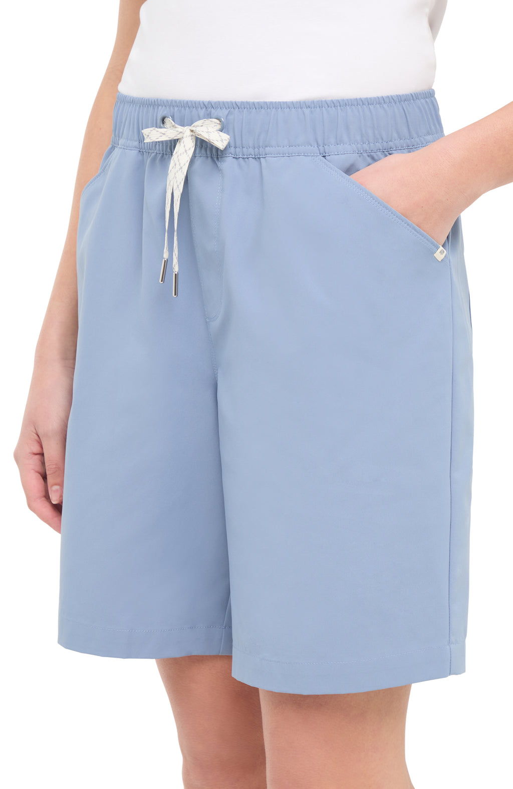 Front view of woman wearing light blue shorts with a white drawstring, with hand in pocket standing on a white background. #color_troposphere