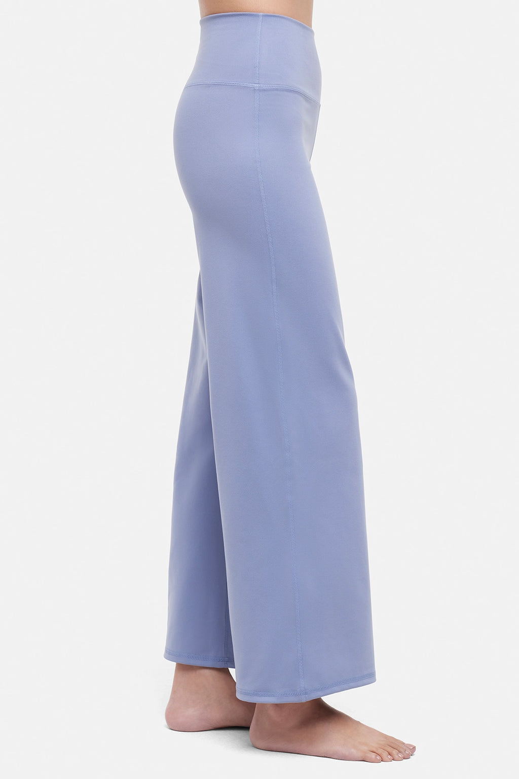 Side view of woman wearing light blue pants on a white background. #color_troposphere
