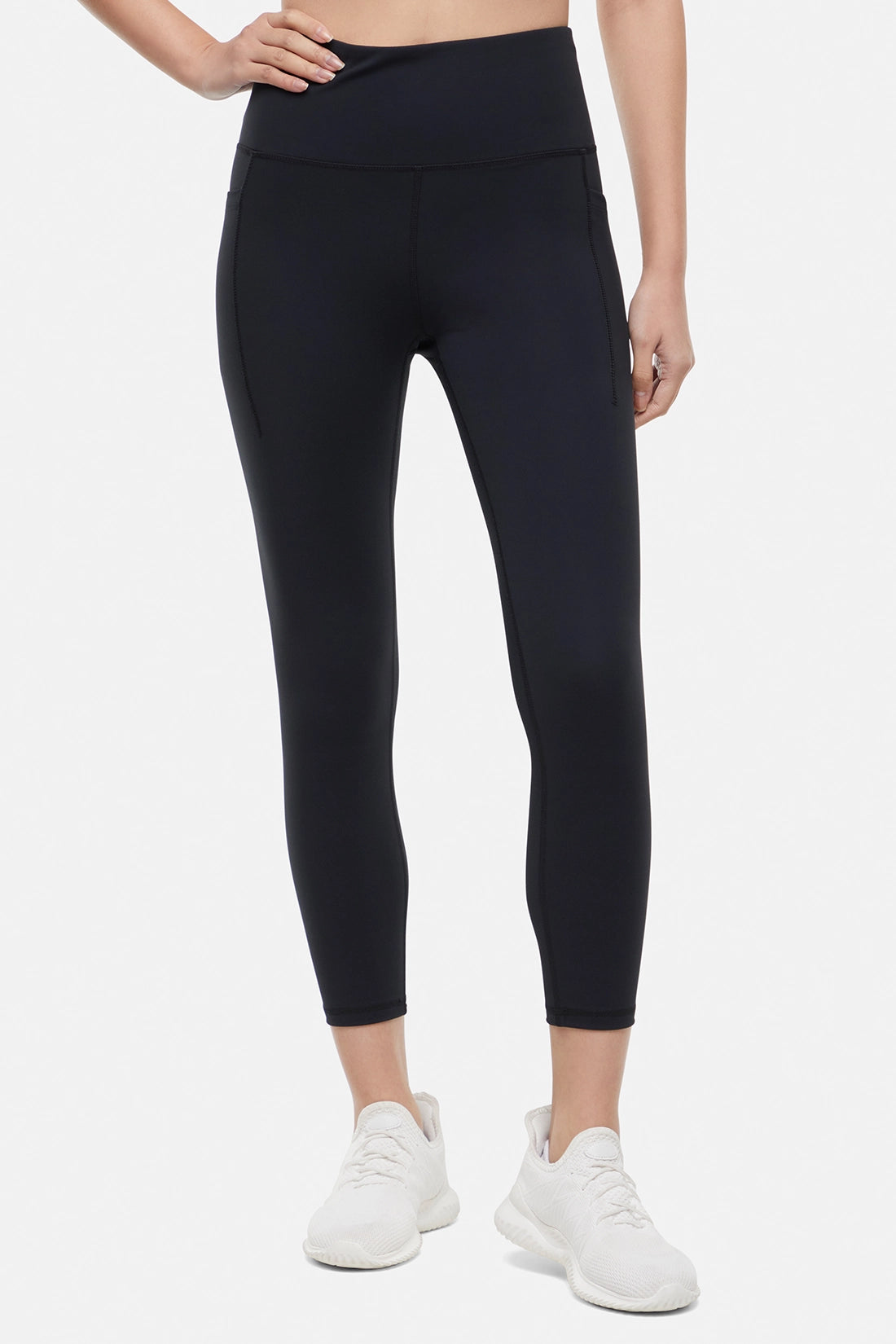 Front view of woman wearing black leggings worn by a person on a white background. 