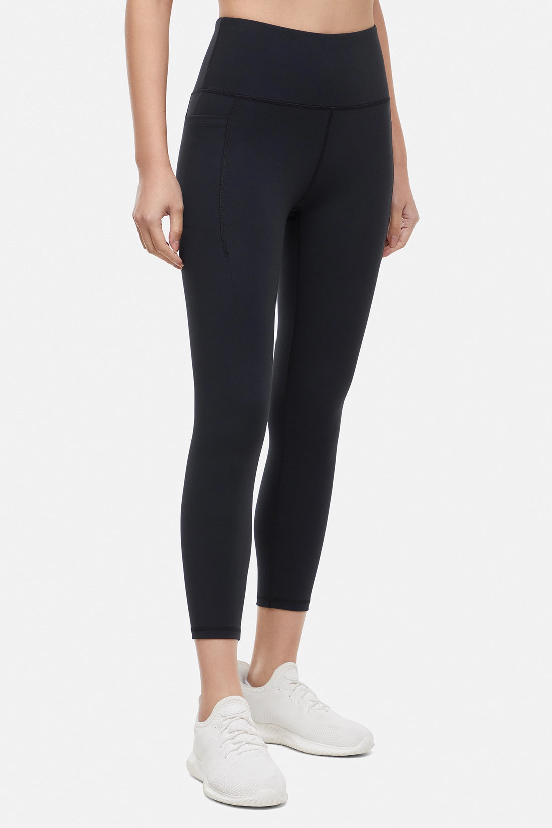 Front view of woman wearing black leggings worn by a person on a white background. 