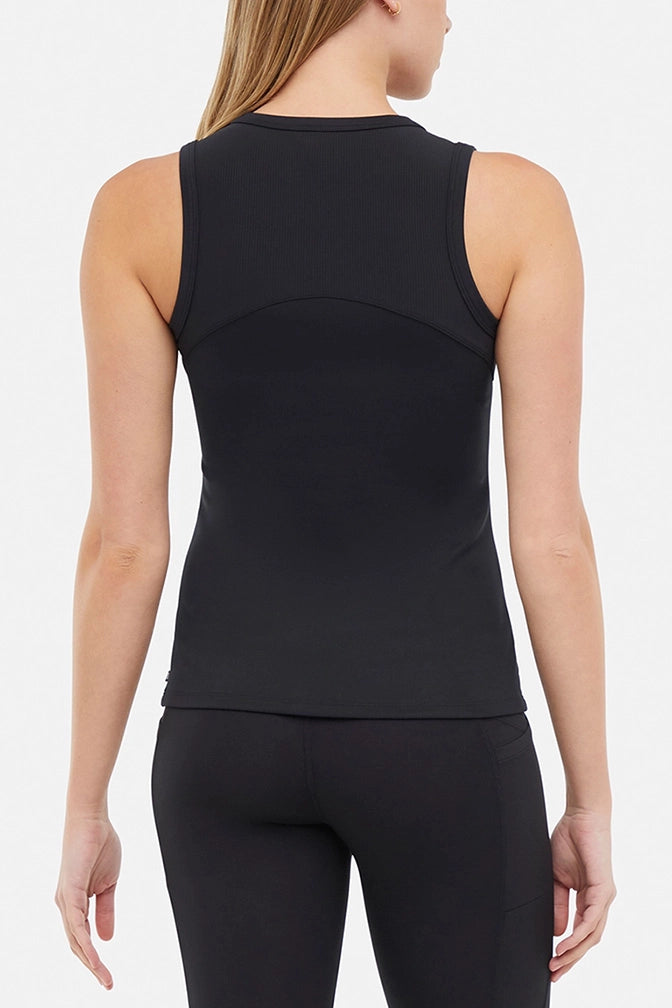 Back view of woman wearing a black ribbed-knit sleeveless tank top and black leggings on a light gray background. #color_black