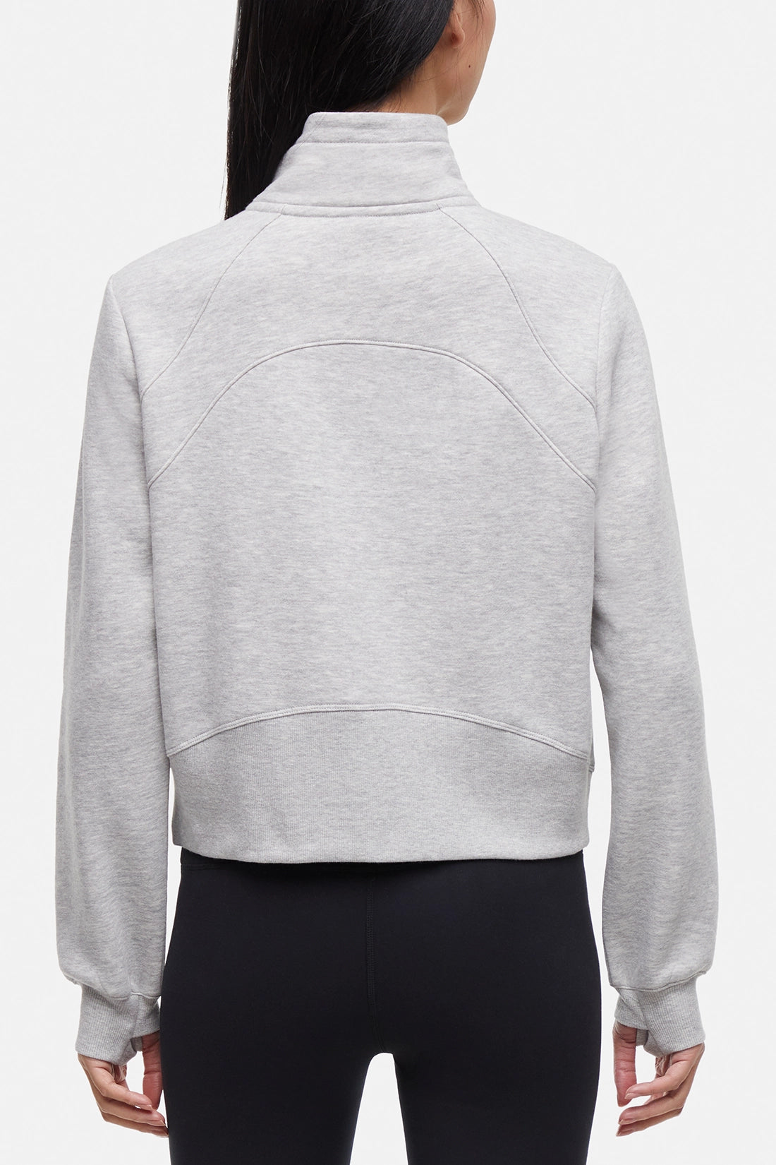 Back view of woman wearing heather gray half-zip pullover with thumbholes  on a white background.