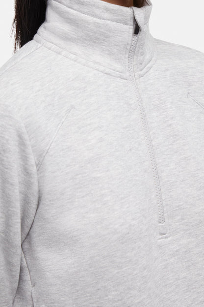 Front close up view of woman wearing heather gray half-zip pullover with thumbholes  on a white background. 