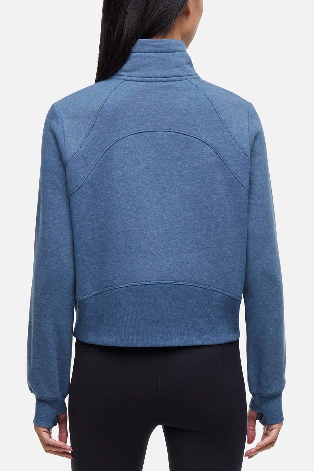 Back view of woman wearing heather blue half-zip pullover with thumbholes on a white background. 