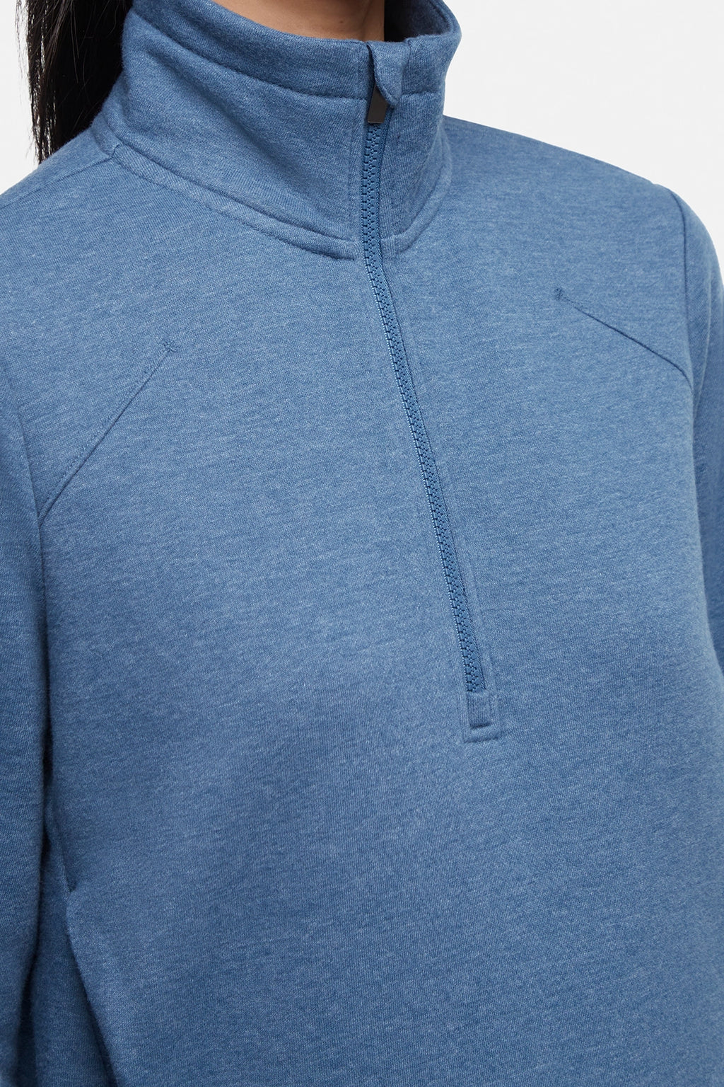 Close up front view of woman wearing heather blue half-zip pullover with thumbholes on a white background. #color_heather-midnight
