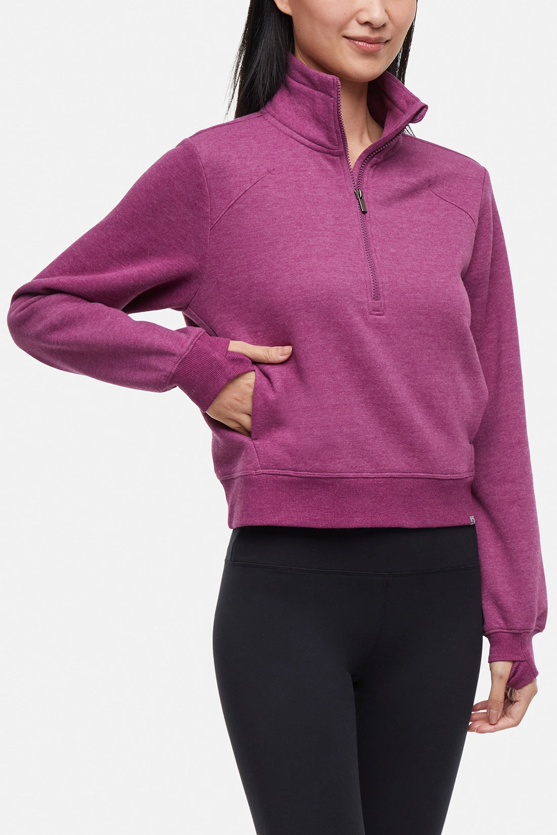 Front view of woman wearing burgundy half-zip pullover with thumbholes on a white background. 