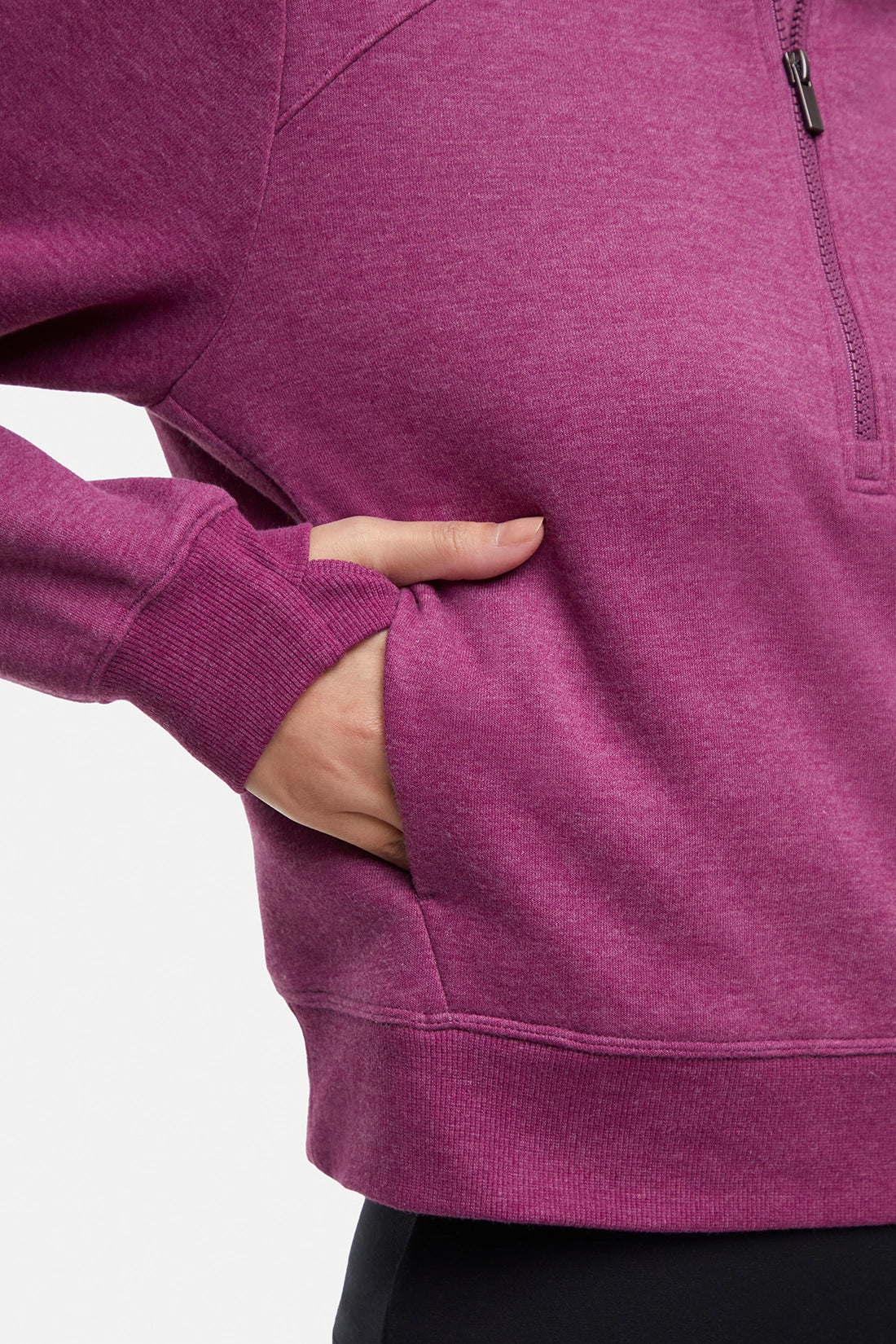 Close up view of woman wearing burgundy thumbholes on a white background. 