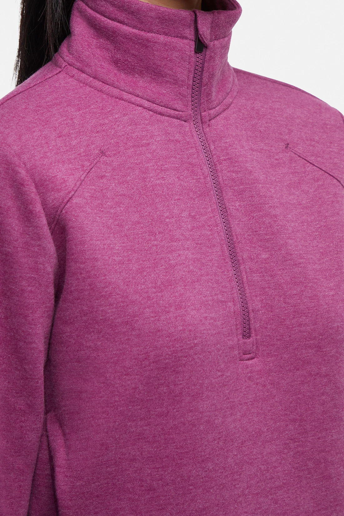 Close-up front view of woman wearing burgundy half-zip pullover with thumbholes on a white background. 