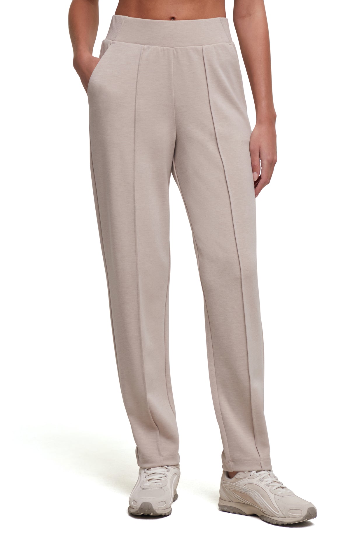 A person wearing light beige tapered-leg cropped pants with a wide elastic waistband and side pockets, paired with light beige sneakers, shown against a plain white studio background. #color_heather-atmosphere