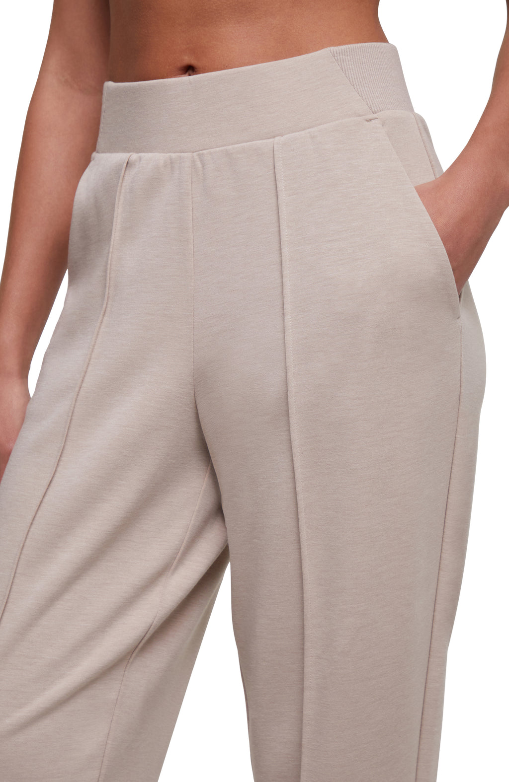 Close-up of a model wearing high-waisted, wide-leg trousers in a light beige or oatmeal heathered fabric, showing the side pocket and front seam details. #color_heather-atmosphere