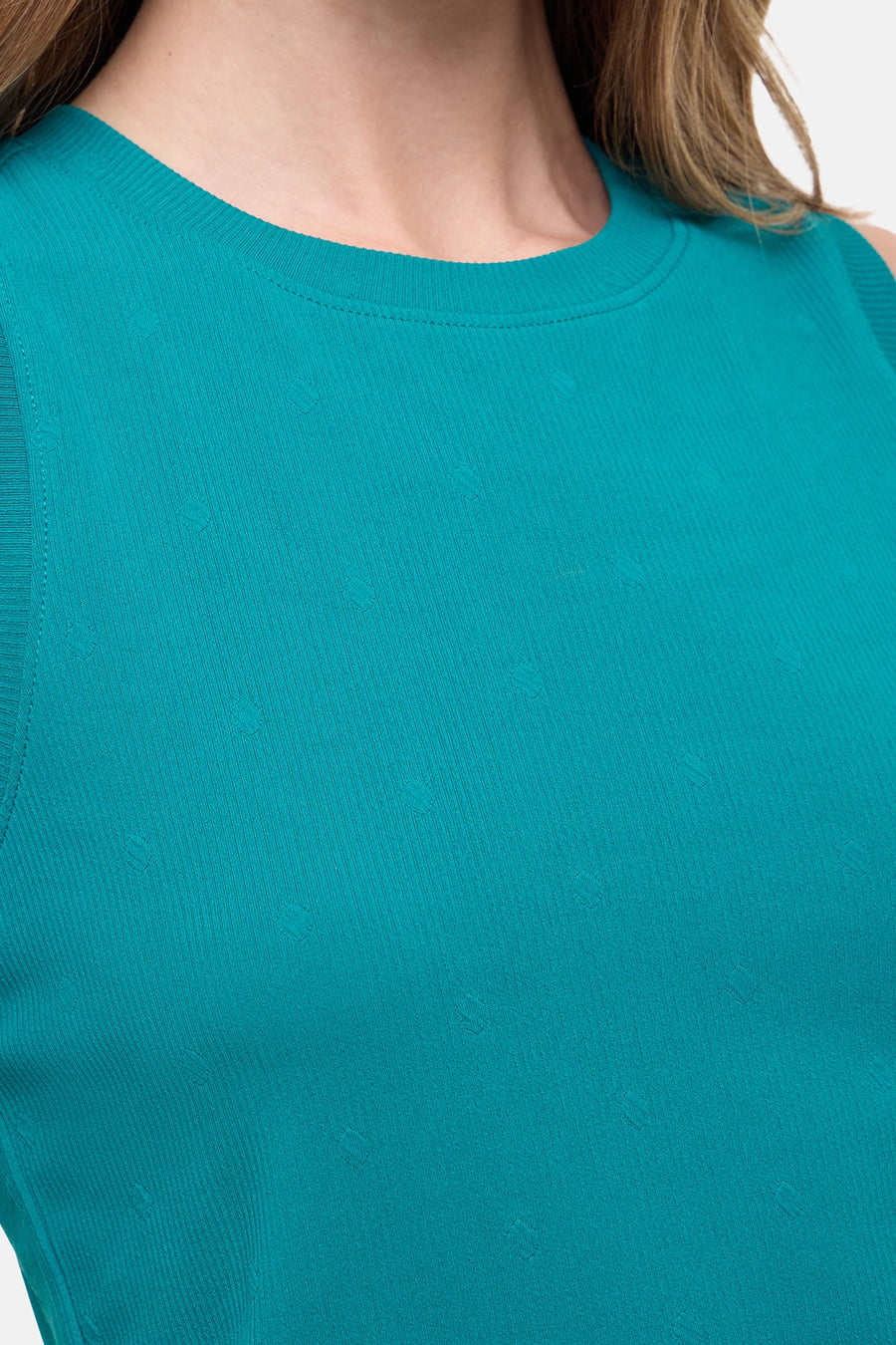 Close up front view of woman wearing a teal sleeveless top and black leggings on a white background. #color_quetzal-green
