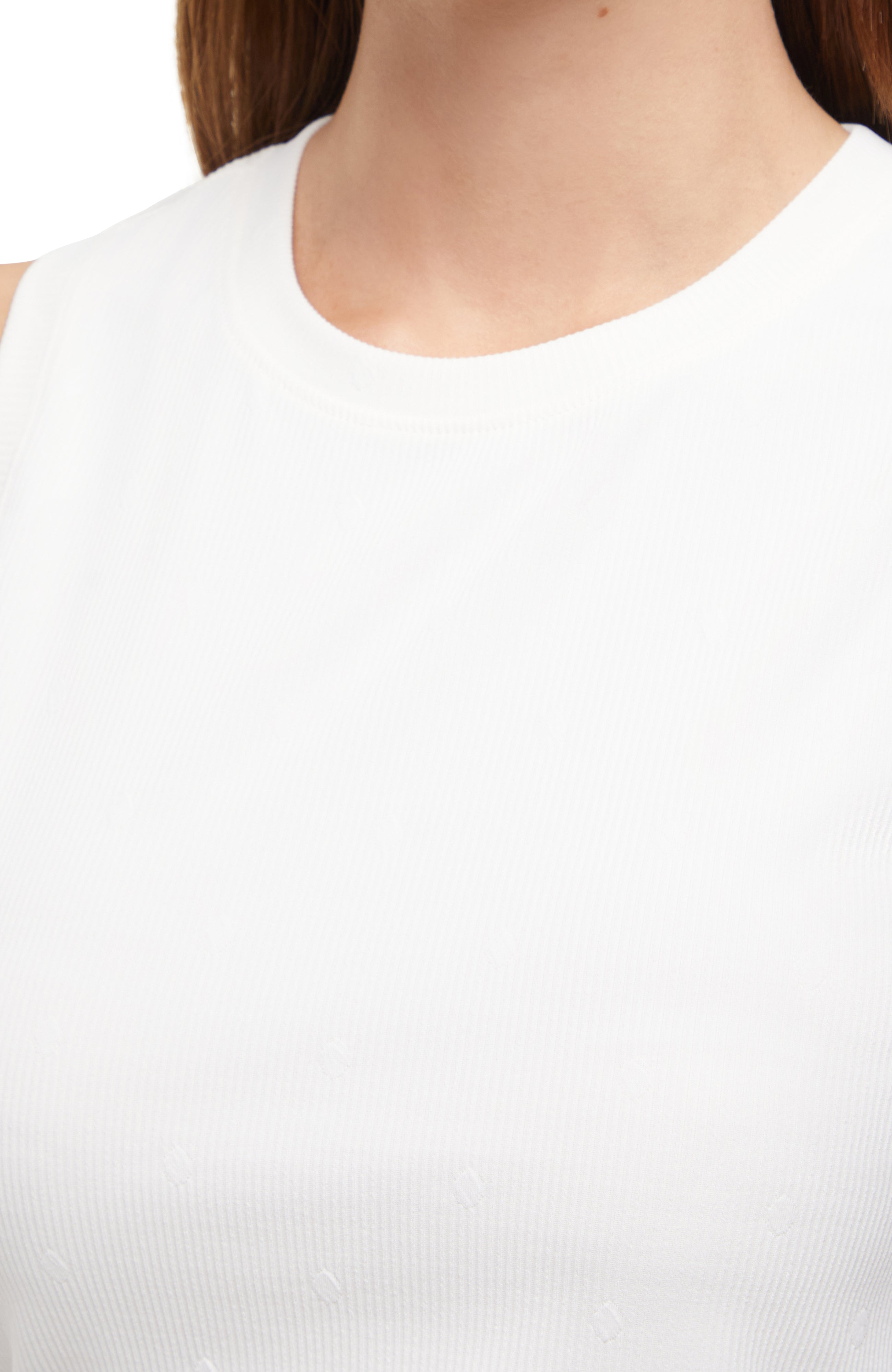Close up neckline view of woman wearing a white sleeveless top and skirt set on a white background. 