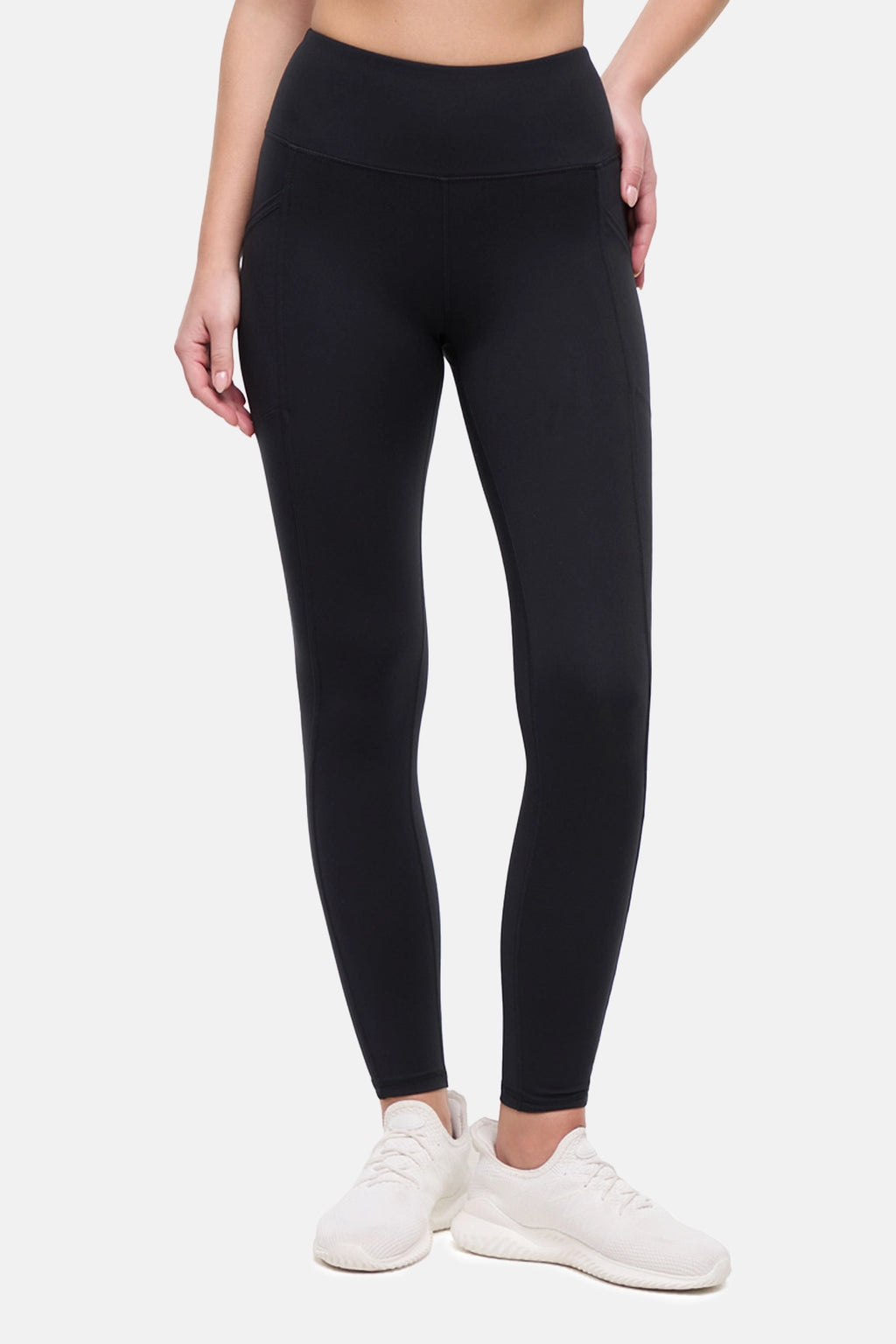 Front view of woman wearing black leggings on a white background. #color_black
