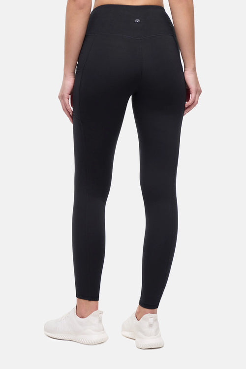 Back view of woman wearing black leggings on a white background. #color_black