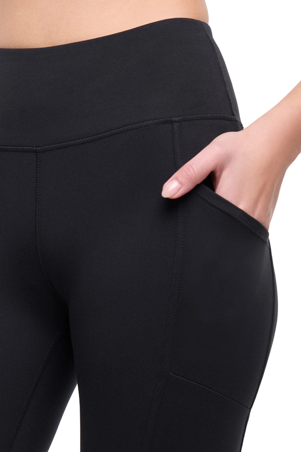 Close up view of woman wearing black leggings with hand in side pocket on a white background. #color_black