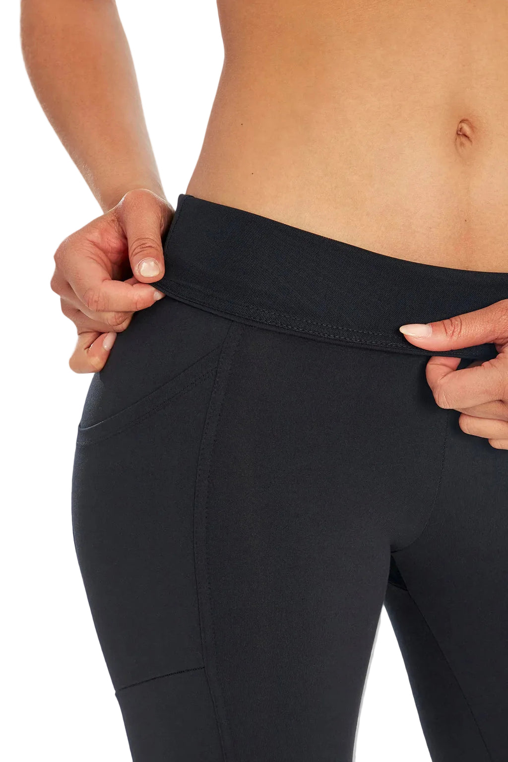Close up front view of woman wearing black leggings folding over waistband on a white background. #color_black