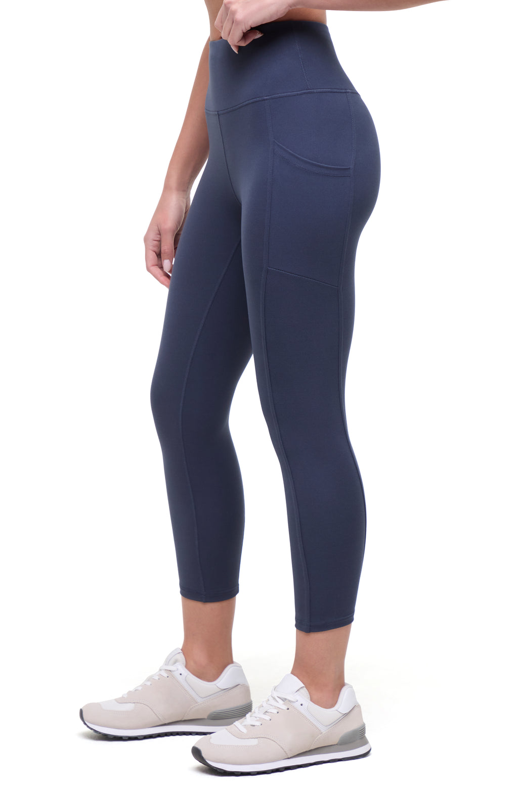 Side view of woman wearing navy blue leggings on a white background. #color_mood-indigo