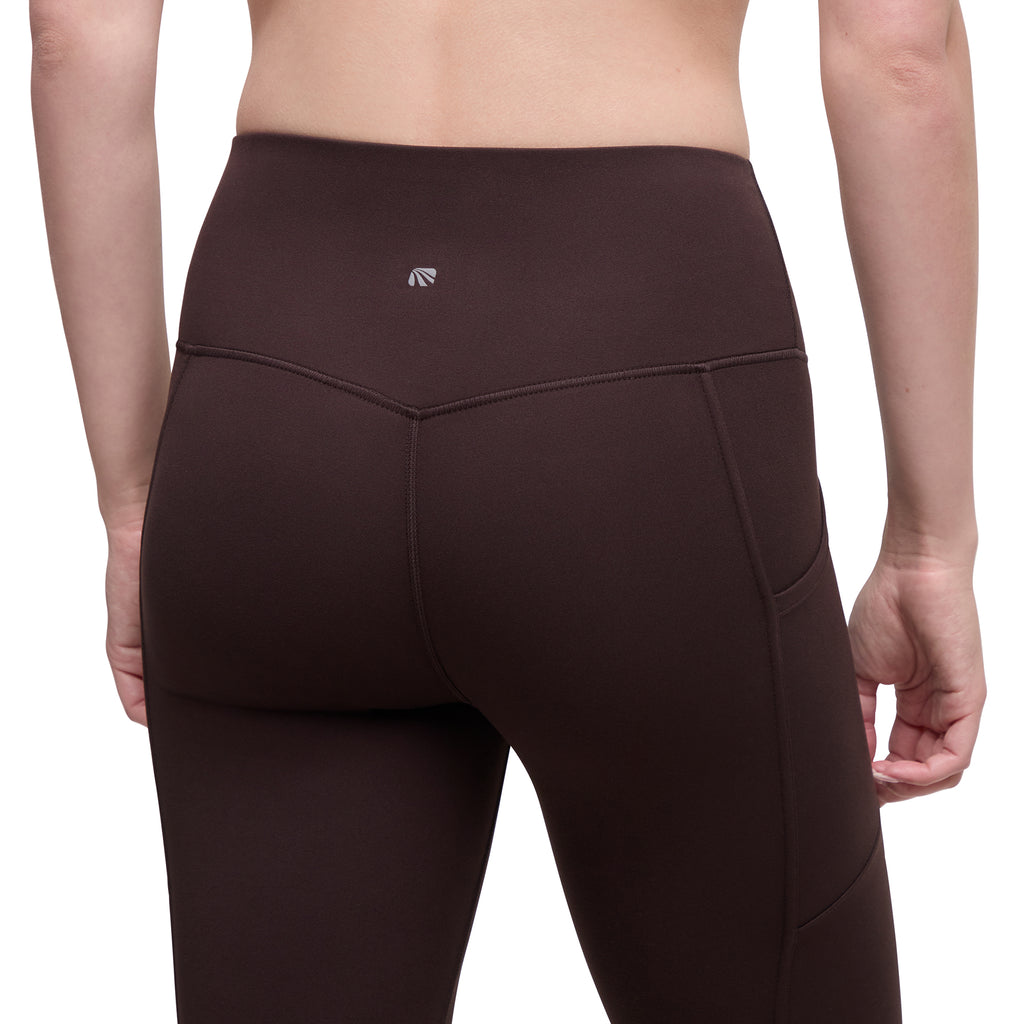 Close up back of high-waisted athletic leggings in a dark brown color, shown from the back on a model against a white background.